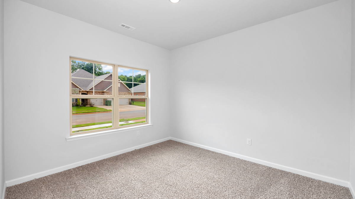 Secondary bedroom with carpet and window
