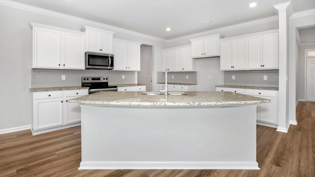 Kitchen island with painted cabinets and stainless steel appliances