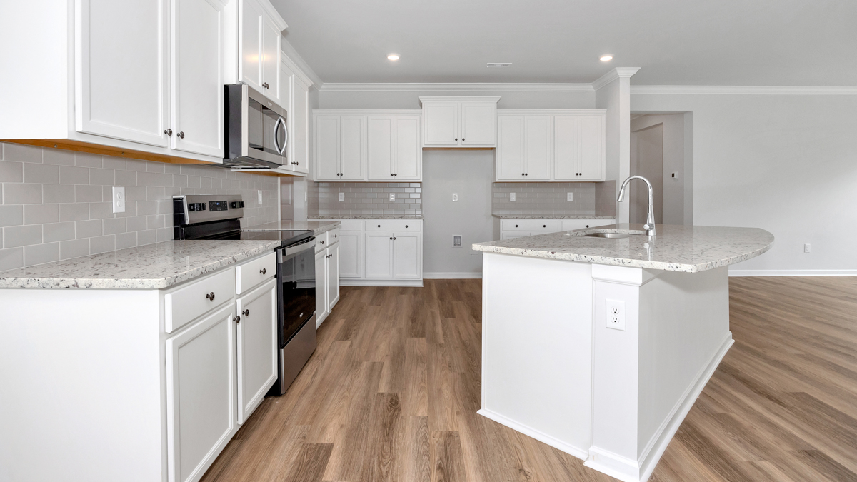 Kitchen island with painted cabinets and stainless steel appliances