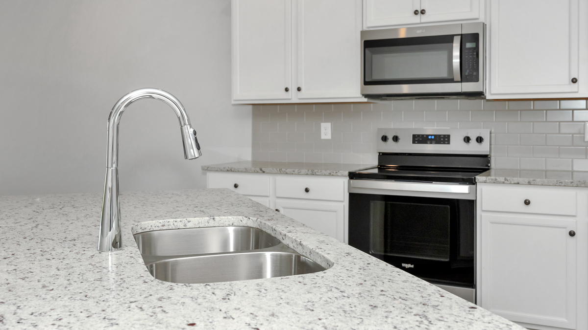 Kitchen sink with granite surround and stainless steel appliances