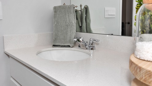 Primary bath with painted cabinets and quartz countertops