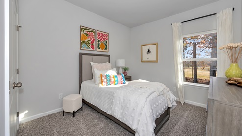 Secondary bedroom with carpet and window