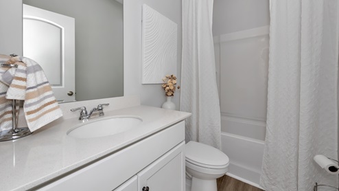 Secondary bathroom with painted cabinets and quartz countertops