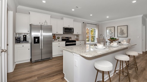 Kitchen island with painted cabinets and stainless steel appliances