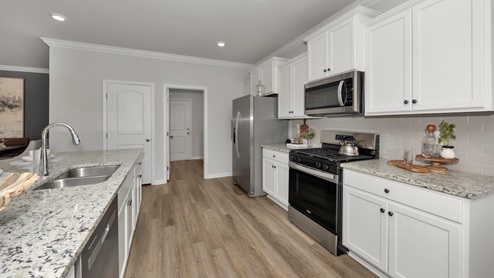Kitchen island with painted cabinets and stainless steel appliances