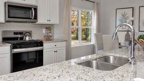 Kitchen sink with granite surround and stainless steel appliances