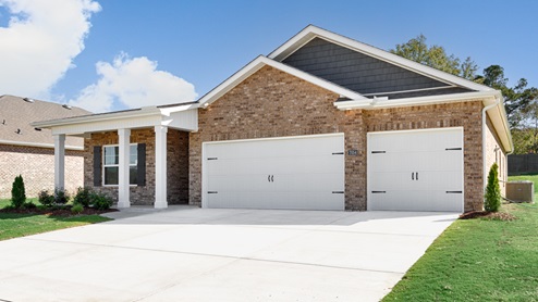 Single story home with brick, covered porch and three car garage