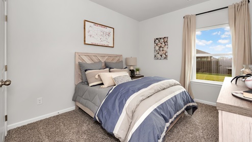 Secondary bedroom with carpet and window