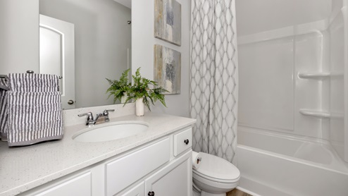 Secondary bathroom with painted cabinets and quartz countertops