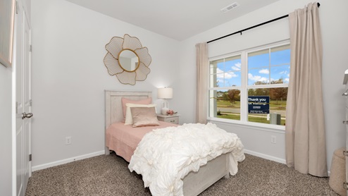 Secondary bedroom with carpet and window