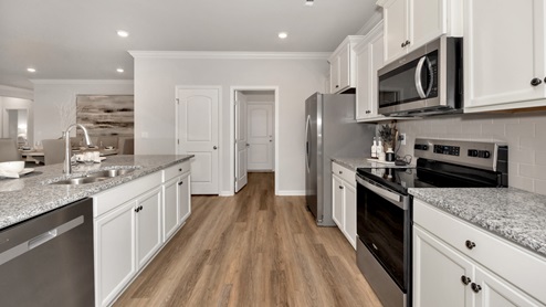 Kitchen island with painted cabinets and stainless steel appliances