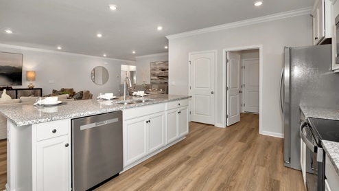 Kitchen island with painted cabinets and stainless steel appliances