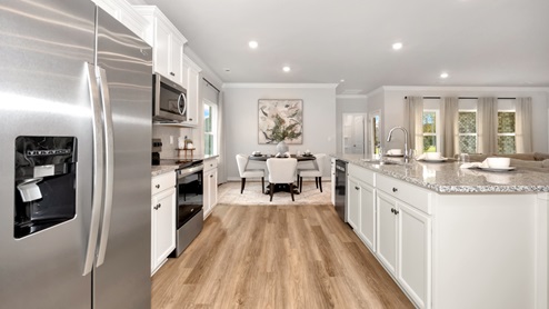 Kitchen island with painted cabinets and stainless steel appliances
