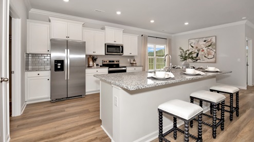 Kitchen island with painted cabinets and stainless steel appliances