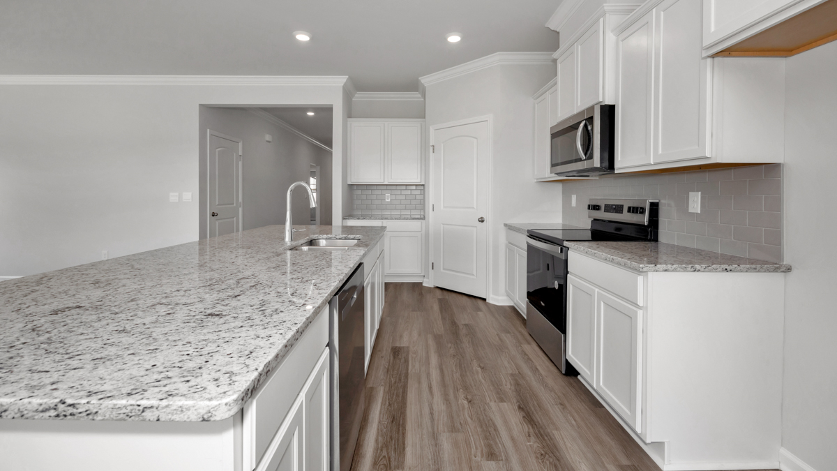 Kitchen island with painted cabinets and stainless steel appliances