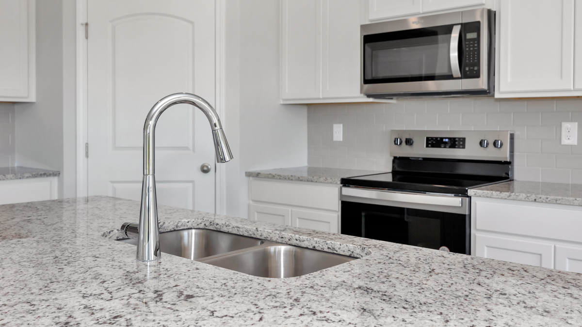 Kitchen sink with granite surround and stainless steel appliances