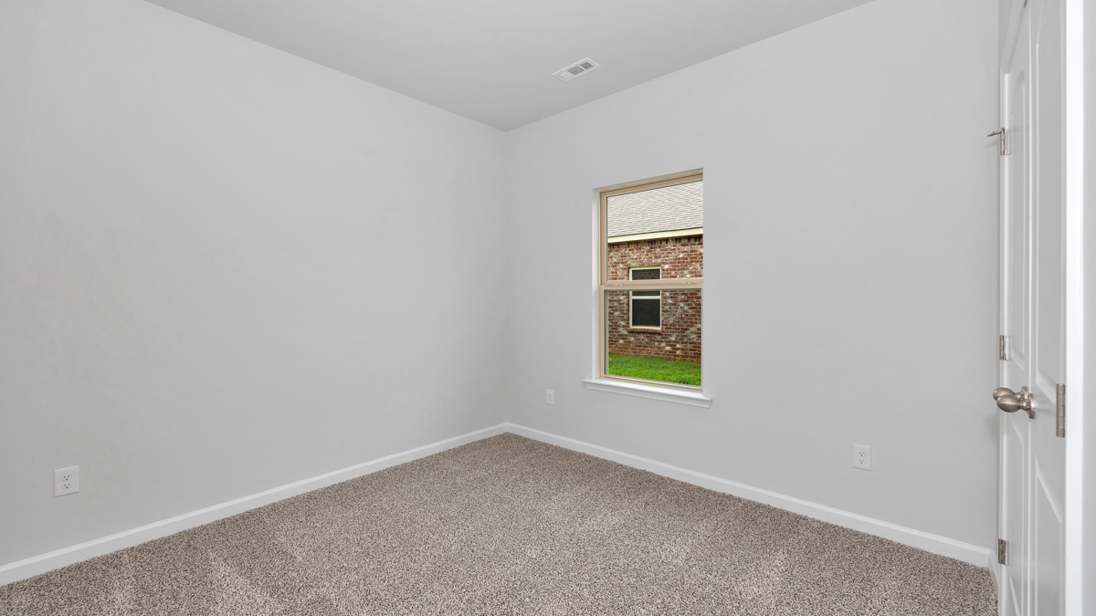 Secondary bedroom with carpet and window