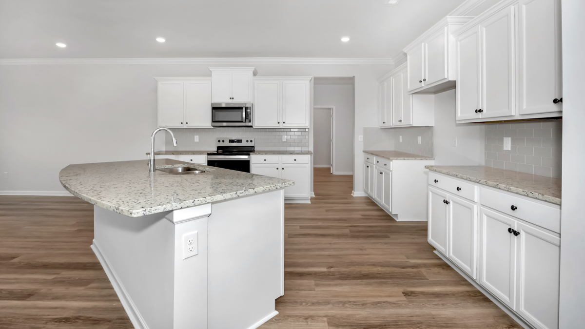 Kitchen island with painted cabinets and stainless steel appliances