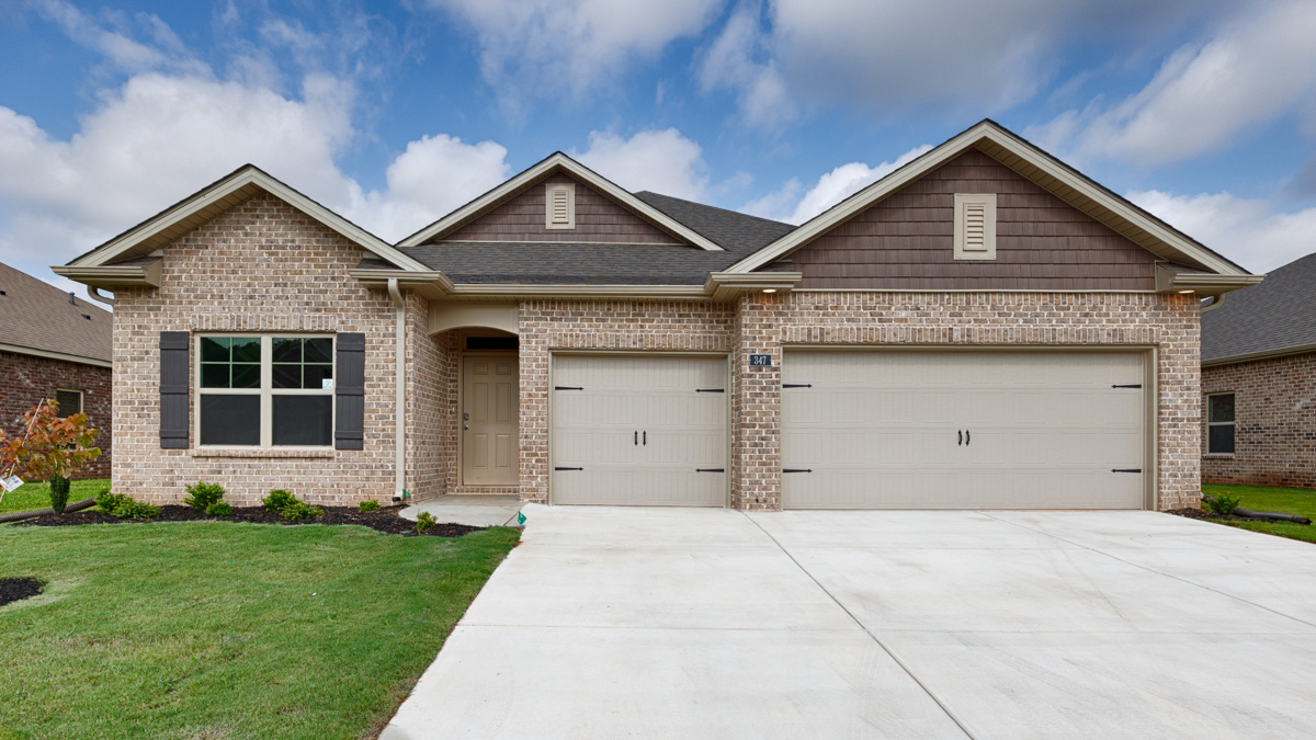 Single story home with brick and three car garage