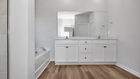 Primary bath with painted cabinets and quartz countertops
