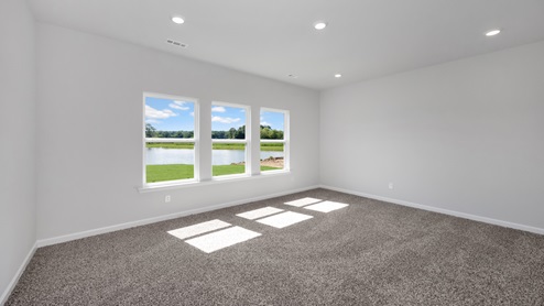 Secondary bedroom with carpet and window