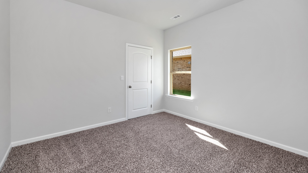 Secondary bedroom with carpet and window