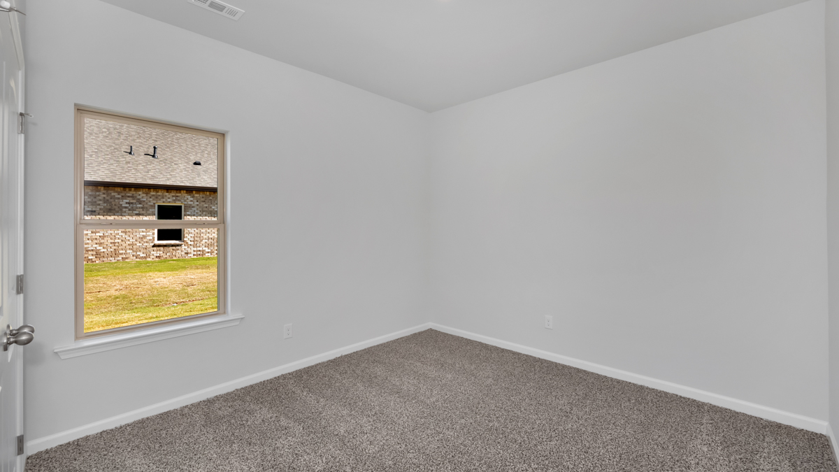 Secondary bedroom with carpet and window