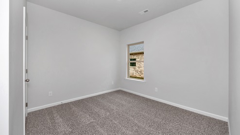 Secondary bedroom with carpet and window