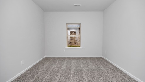 Secondary bedroom with carpet and window