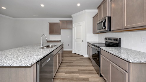 Kitchen island with stained cabinets and stainless steel appliances
