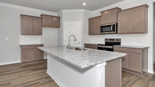 Kitchen island with stained cabinets and stainless steel appliances