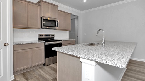 Kitchen island with stained cabinets and stainless steel appliances