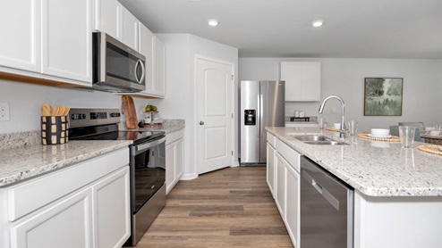 Kitchen island with painted cabinets and stainless steel appliances