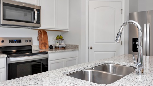 Kitchen sink with granite surround and stainless steel appliances