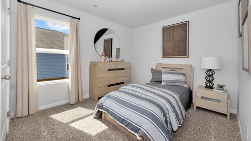 Secondary bedroom with carpet and window