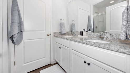 Primary bath with painted cabinets and quartz countertops