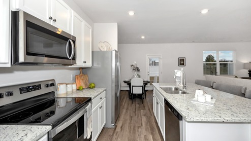Kitchen island with painted cabinets and stainless steel appliances