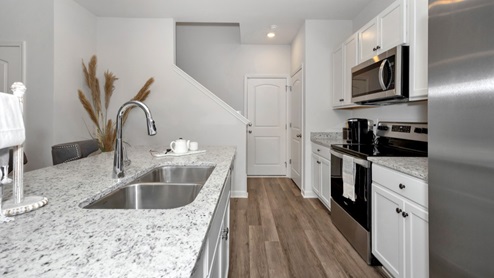 Kitchen island with painted cabinets and stainless steel appliances