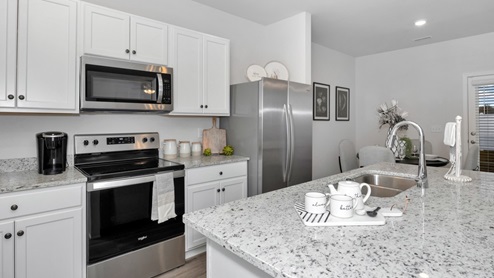 Kitchen island with painted cabinets and stainless steel appliances