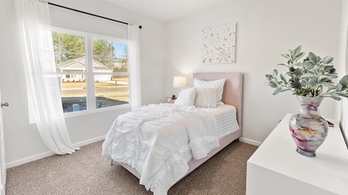 Secondary bedroom with carpet and window