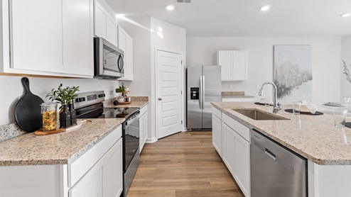 Kitchen island with painted cabinets and stainless steel appliances