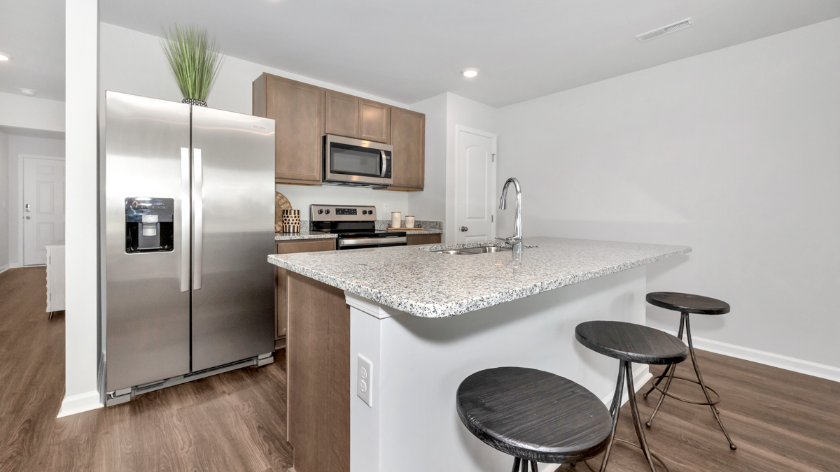 Kitchen island with stained cabinets and stainless steel appliances