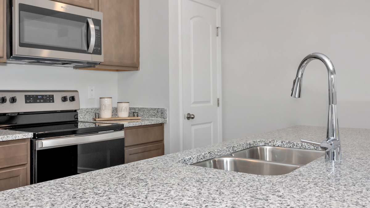 Kitchen sink with granite surround and stainless steel appliances