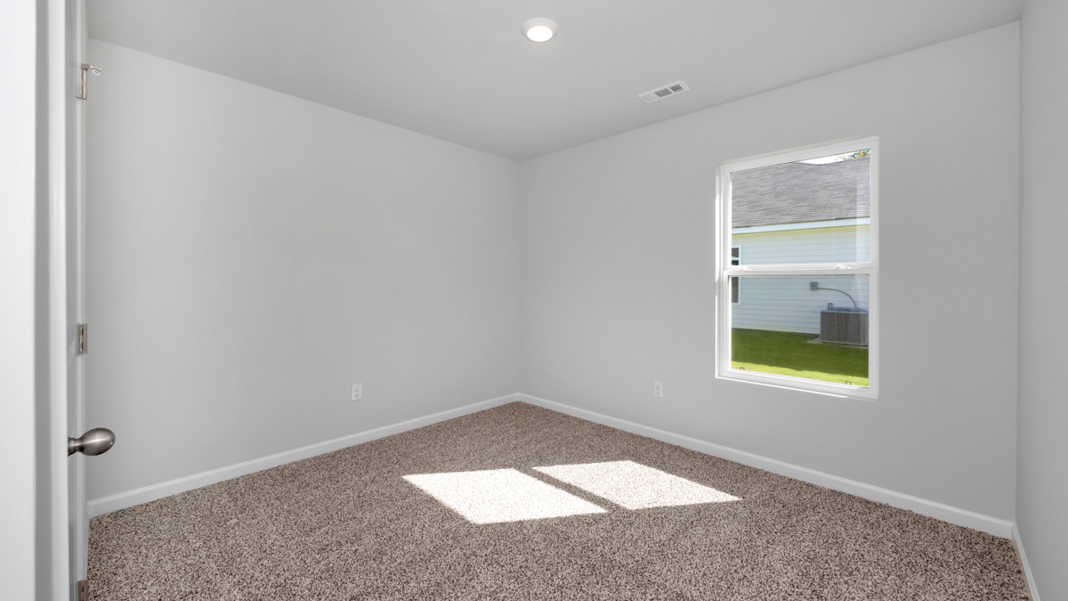 Secondary bedroom with carpet and window
