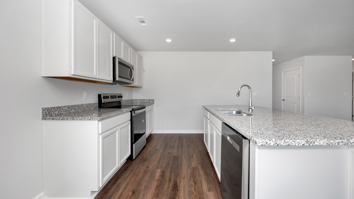 Kitchen island with painted cabinets and stainless steel appliances