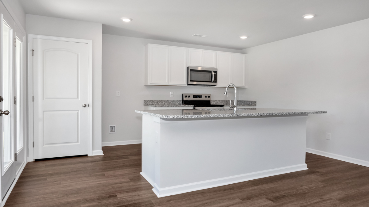 Kitchen island with painted cabinets and stainless steel appliances