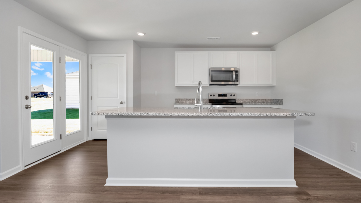 Kitchen island with painted cabinets and stainless steel appliances