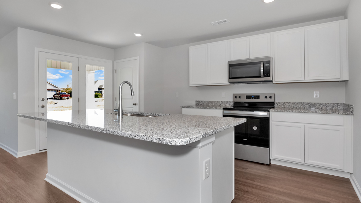 Kitchen island with painted cabinets and stainless steel appliances