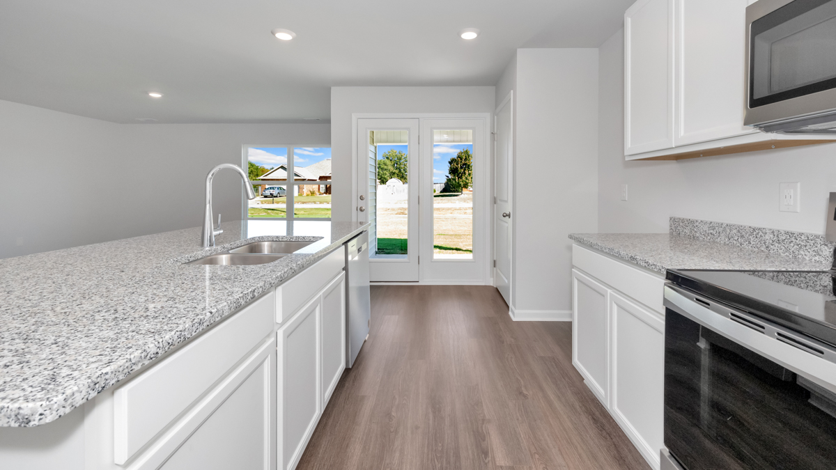 Kitchen island with painted cabinets and stainless steel appliances