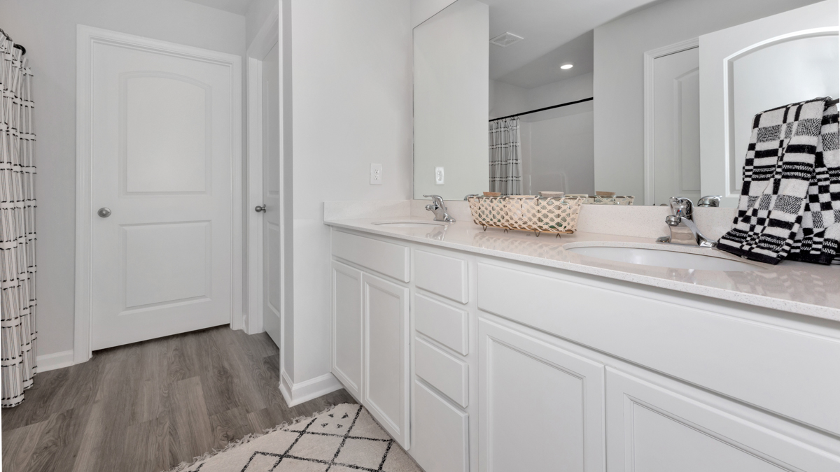 Primary bath with painted cabinets and quartz countertops